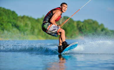 Wakeboarder surfing across a lake