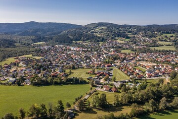 Fototapeta na wymiar Bild einer Luftaufnahme der Gemeinde Frauenau im bayerischen Wald mit Landschaft und Bergen im Hintergrund, Deutschland