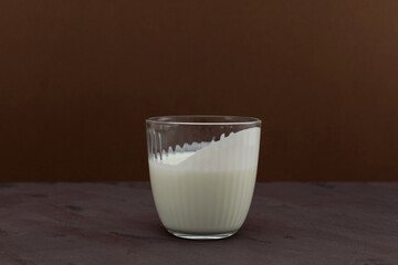 Sour milk drink. Diet for weight loss. Ayran or kefir in a glass on brown background. Fermented milk ayran.  Selective focus, copy space