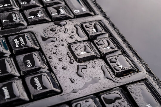 Water drops on the computer keyboard. Water flooded computer keys.