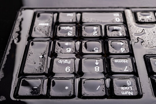 Water Drops On The Computer Keyboard. Water Flooded Computer Keys.