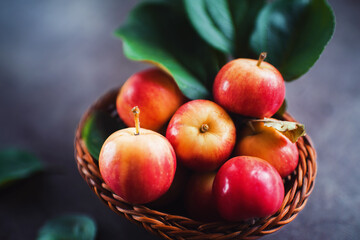 Ripe red small apples in the basket in  on dark table.  Autumn harvest. Macro