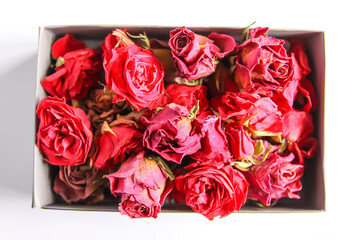 Red rose dry buds, flowers and petals in the opened cardboard box