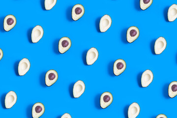 Avocado halves pattern on a blue background