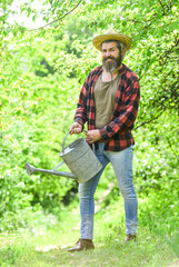 summer farm. agriculture and tough work concept. Gardening or planting concept. Man using a big watering can for planting. pour the water. man with watering can. gardening and watering plants