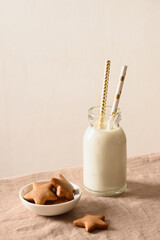 Homemade cookies in shape of star and milk for Santa on table with tablecloth. Close up.