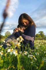woman hugging a child in a flower field