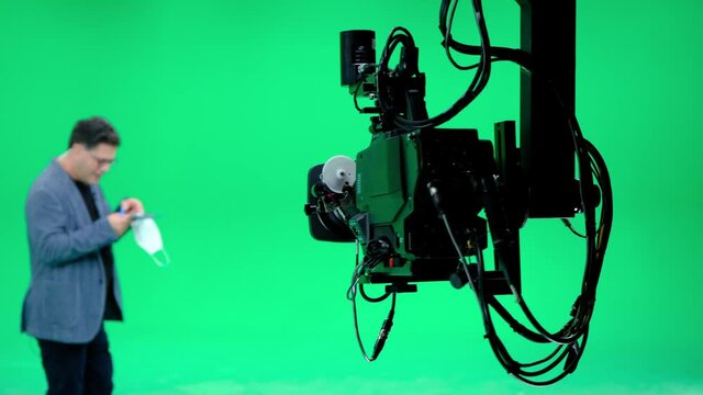 In a professional green screen studio, the camera jib shooting the television presenter. Film and Television Industry