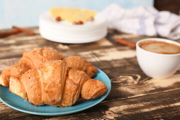 Breakfast with coffee and croissants on wooden background