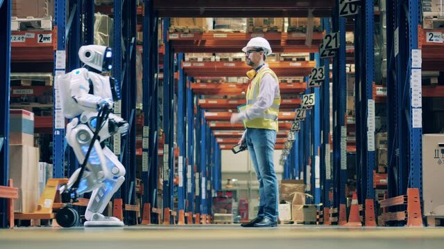 Worker stops warehouse robot to scan barcodes on boxes