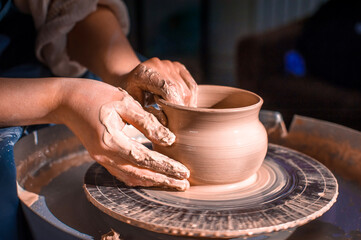 Fototapeta na wymiar production process of pottery. Forming a clay teapot on a potter's wheel.