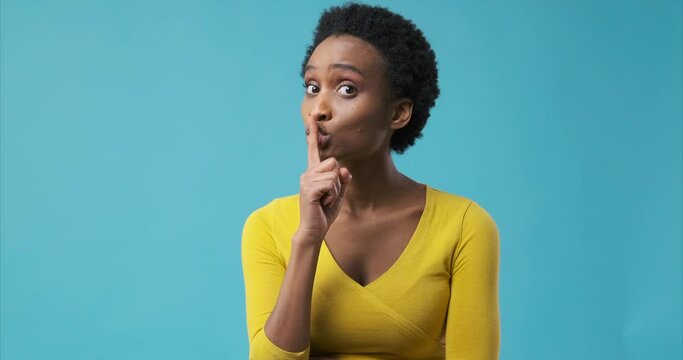 African american woman gesturing with finger on her lips