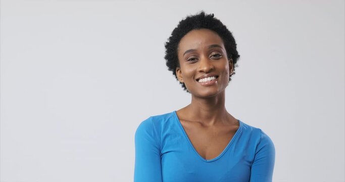 Beautiful african american woman smiling over white background
