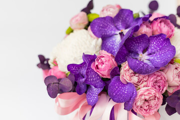 Flower arrangement in a gift box for a woman. Flowers bouquet with purple vanda orchids, white chrysanthemums, pink roses and eucalyptus. A festive concept. Place for text. white background.