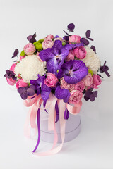 Flower arrangement in a gift box for a woman. Flowers bouquet with purple vanda orchids, white...