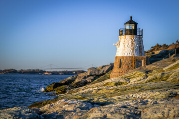 Fototapeta na wymiar A small lighthouse hugs the Rhode Island shore