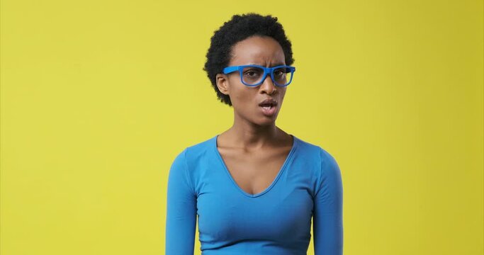 African american woman saying no by waving her finger over yellow background