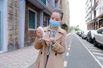 Fototapeta premium Business female in face protective mask on urban street. Health protection and social distance concept. Lockdown quarantine time. Hand hygiene.
