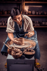 The potter works in the workshop. Hands and a potter's wheel close-up.