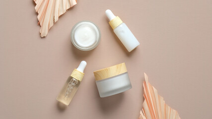 Cosmetic packaging set on pastel beige background. Natural organic beauty products and dry leaves. Skincare concept.