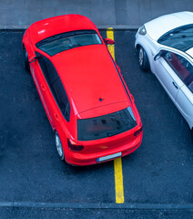 Bad parking. Improperly parked car. Cars in the parking. View from above. red car