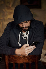 man with a phone and hoody 