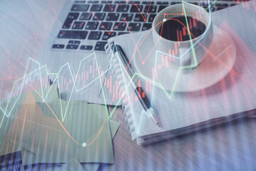Double exposure of forex chart drawing and desktop with coffee and items on table background. Concept of financial market trading
