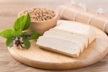 Sliced tofu and soybean seeds on wooden cutting board prepare for cooking, Asian vegan food