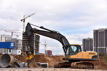 Excavator during earthmoving at construction site. Backhoe dig ground for the construction of...