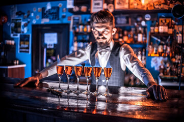 Focused bartender formulates a cocktail in pub
