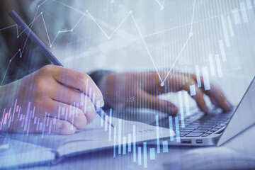 Double exposure of businesswoman hands typing on computer and forex chart hologram drawing. Financial analysis concept.