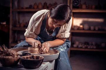 Young female potter working on a potter's wheel.