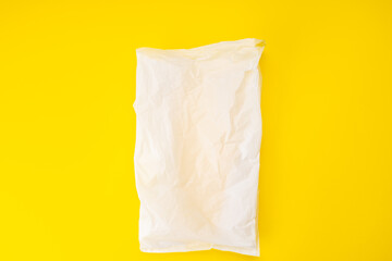 white plastic bag isolated on a yellow background. plastic pollution problem concept. above view