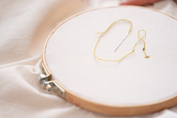 aguja enhebrada en bastidor de bordado