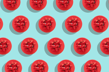 Pattern red gift box with decorative bow on blue surface top view flat lay. Holiday concept new year or Christmas gift box presents Xmas holiday. Congratulations background