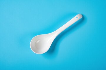 top view ceramic soup spoon on a blue background