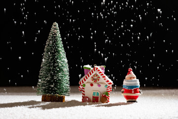 Christmas house and fir tree and a Santa Claus with medical mask in a snowing night