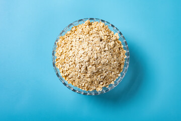top view glass bowl of oatmeal on blue background