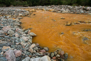 Unique yellow river called River of Gold due to the presence of iron, flowing along the rocky valley.