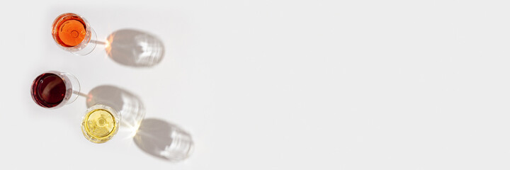 Set of wine in glasses with beautiful shadows. Banner with red, rose and white wine