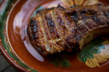 Hot grilled meat in plate on the rustic background. Selective focus.