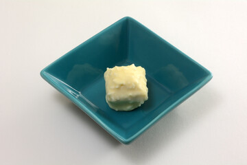 Boiled milk and chocolate cake snack in blue candy dish in white background