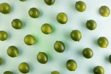 Pattern of natural green lemons on a light green background

