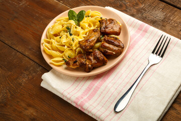 Cheese plate of pasta in a creamy sauce with cheese and chicken on the table on a napkin next to a fork.
