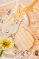 Fototapeta na wymiar Yellow flower with clear crystals on white fabric textured background