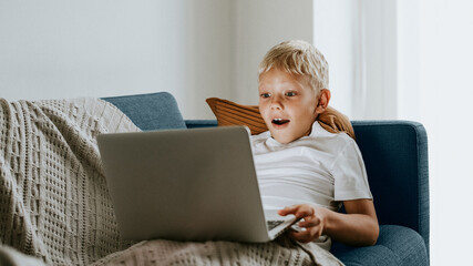 Young boy watching videos on his laptop