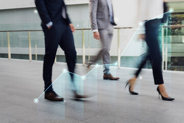 Businessmen and a businesswoman walking in a city during rush hour