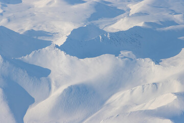 Aerial view of snow-capped mountains. Winter snowy mountain landscape. Travel to the far north of Russia. Kolyma Mountains, Magadan Region, Siberia, Russian Far East. Great for the background.