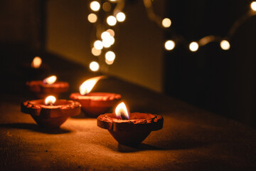 Diwali Diya oil lamp lit during diwali festival in India with bokeh lights isolated in black...