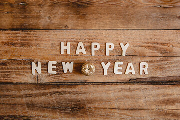 Happy new year inscription in wooden letters on a wooden table. Top view